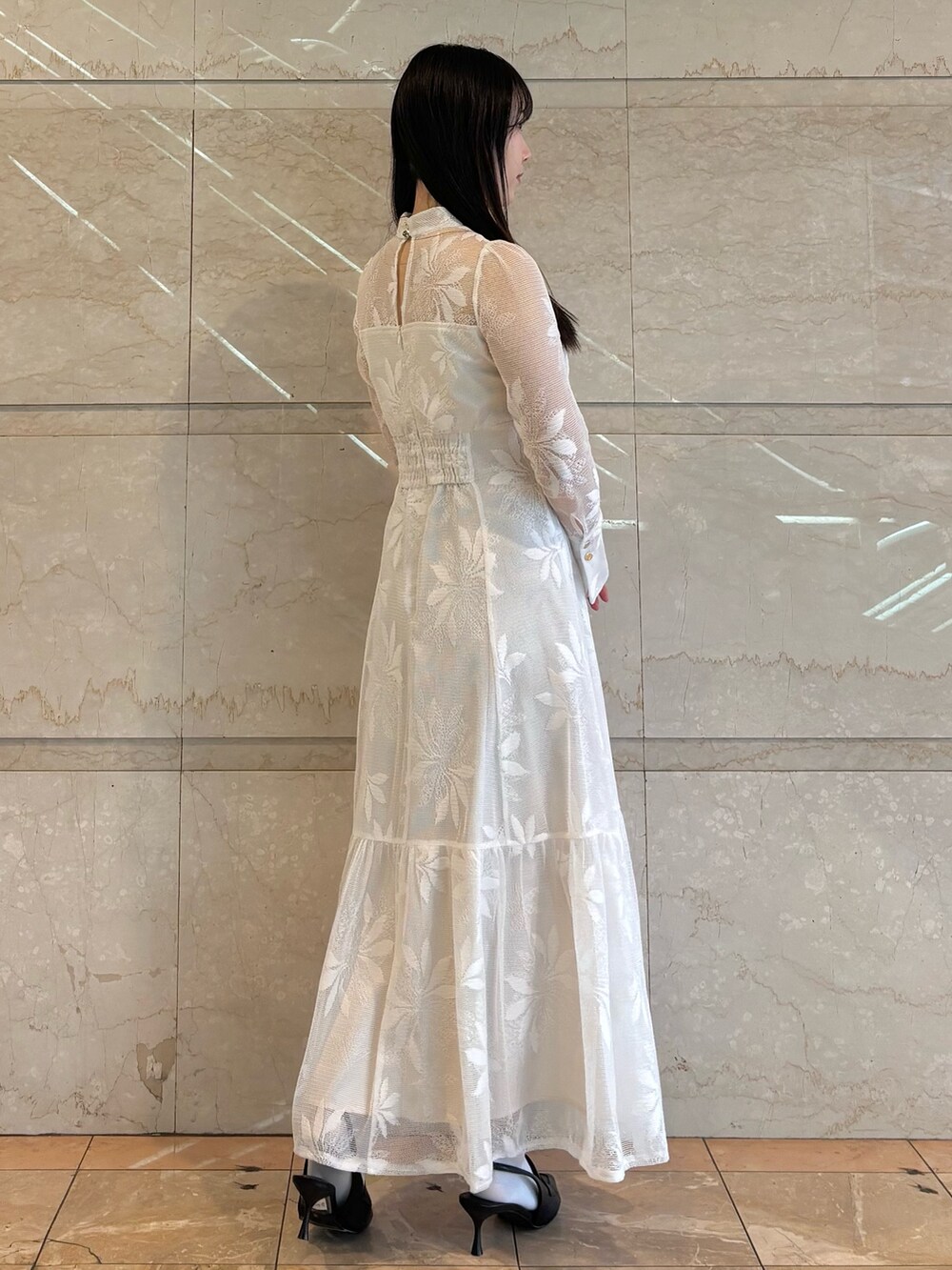 ホワイト系のワンピース、ブラック系のパンプスを着用したレディースの冬コーディネートの4枚目の写真