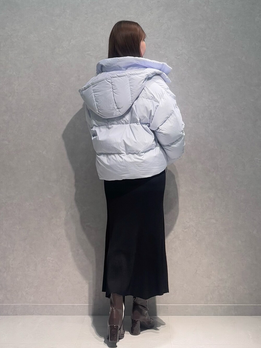 ブラック系のワンピース、ブルー系のダウンジャケット/コート、ブラウン系のブーツを着用したレディースの冬コーディネートの4枚目の写真