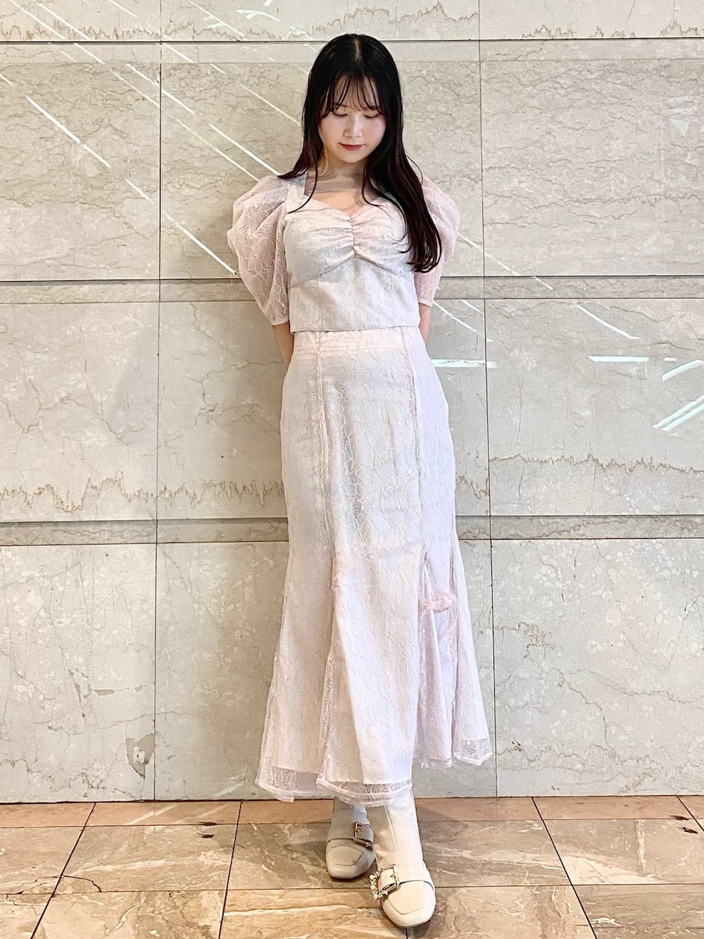 ベージュ系のスカート、ベージュ系のシャツ/ブラウス、ホワイト系のブーツを着用したレディースの冬コーディネートの2枚目の写真