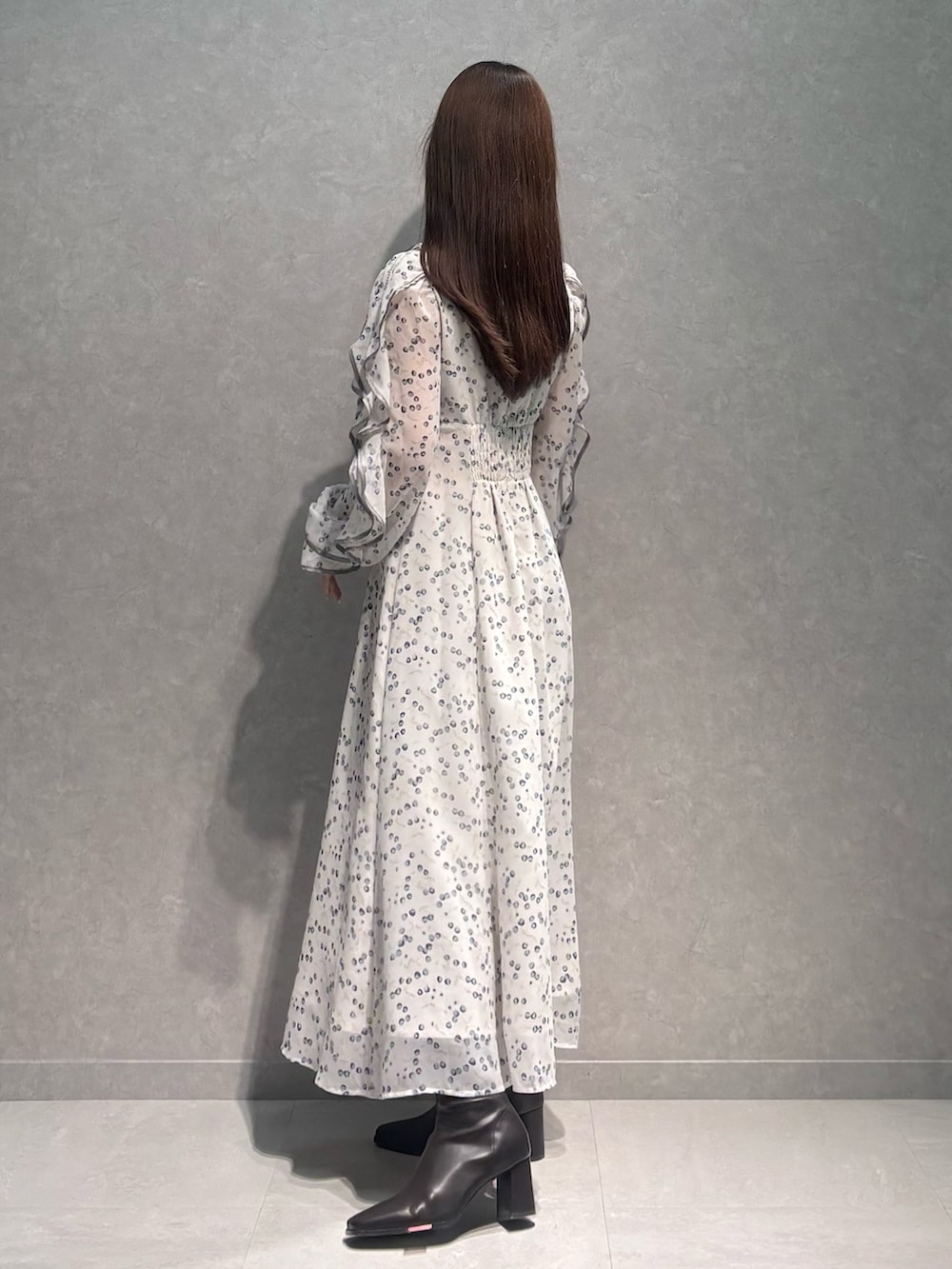 ホワイト系のワンピース、ブラウン系のブーツを着用したレディースの冬コーディネートの3枚目の写真