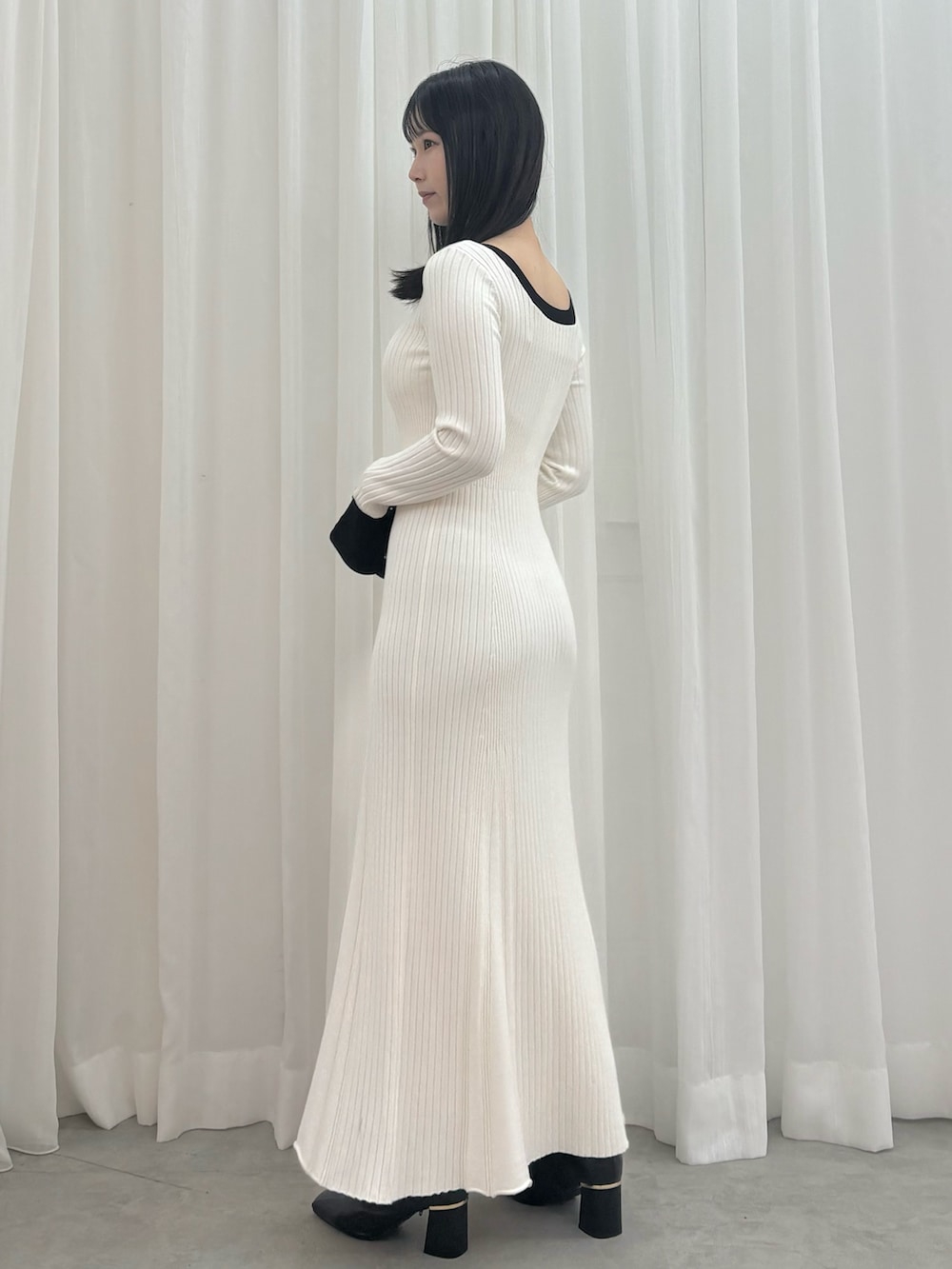 ホワイト系のワンピース、ブラック系のブーツを着用したレディースの秋コーディネートの3枚目の写真