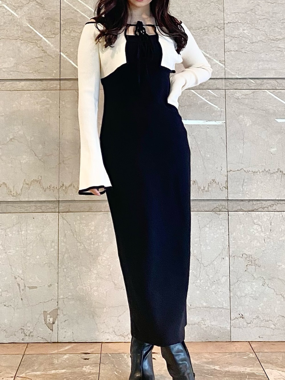 ブラック系のワンピース、ブラック系のブーツを着用したレディースの秋コーディネートの5枚目の写真