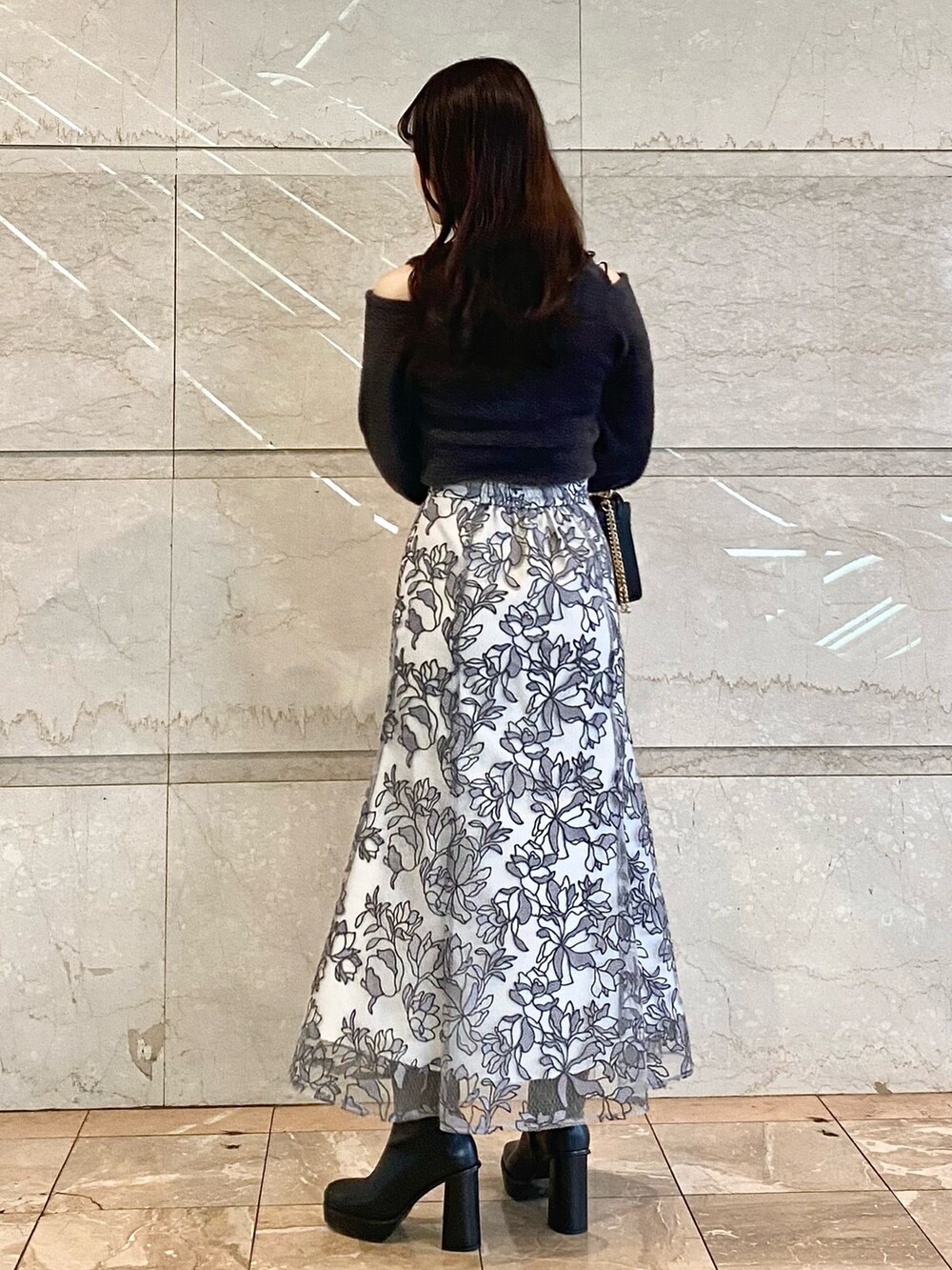 ブラック系のブーツ、ブラック系のショルダーバッグ、グレー系のニット/セーターを着用したレディースの秋コーディネートの4枚目の写真