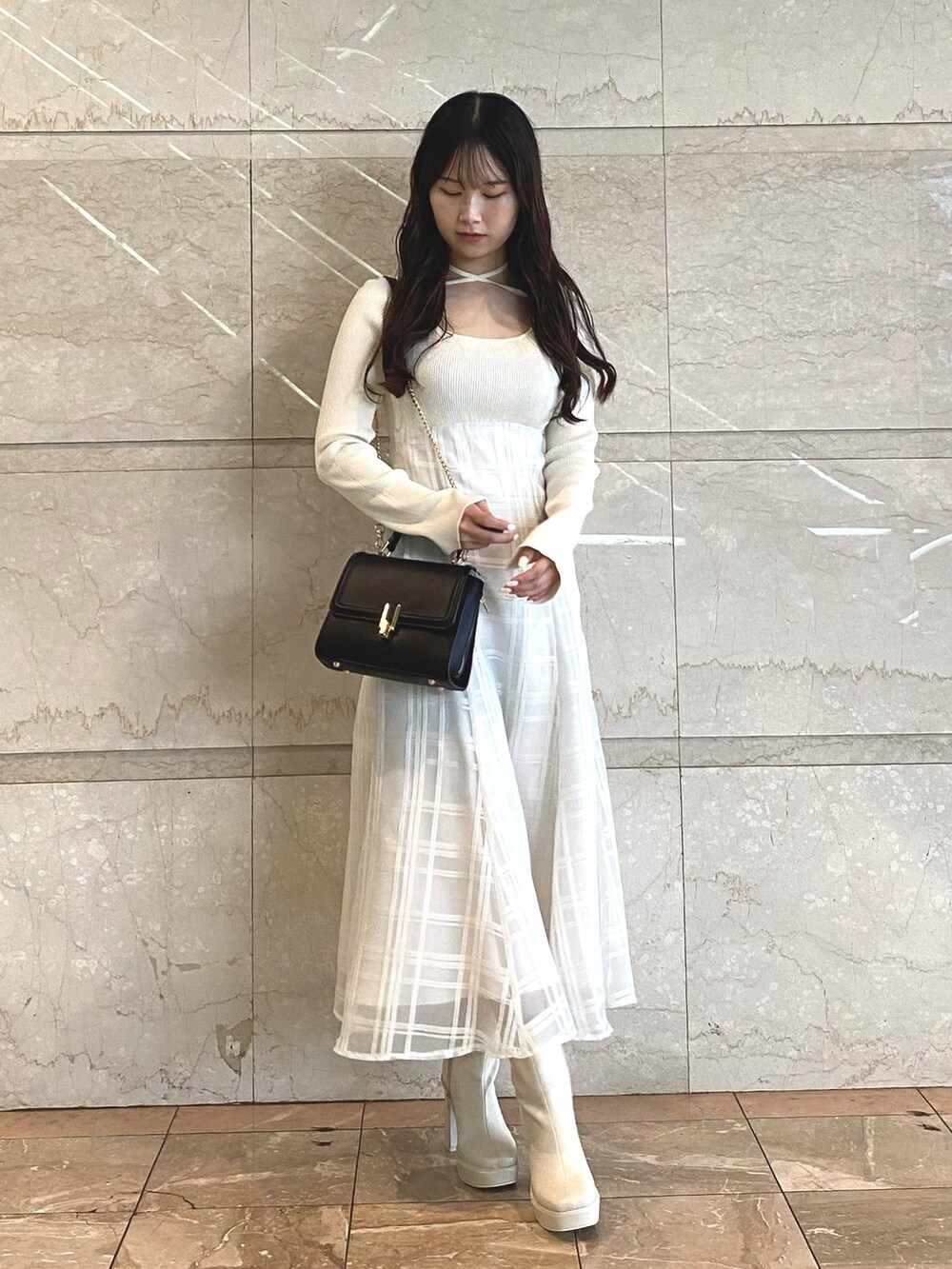 ホワイト系のワンピース、ホワイト系のブーツ、ブラック系のショルダーバッグを着用したレディースの秋コーディネートの6枚目の写真