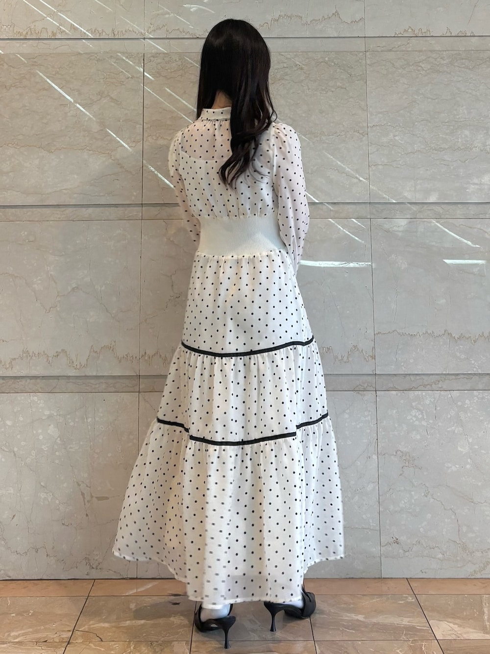 ホワイト系のワンピース、ブラック系のパンプスを着用したレディースの冬コーディネートの4枚目の写真