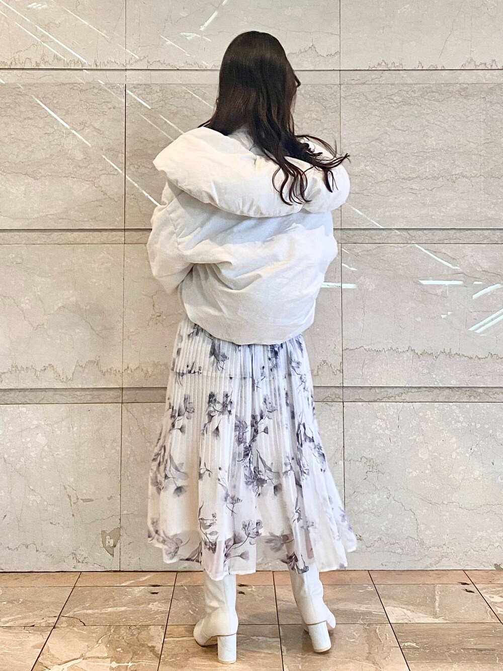 ピンク系のワンピース、ホワイト系のダウンジャケット/コート、ホワイト系のブーツを着用したレディースの冬コーディネートの3枚目の写真