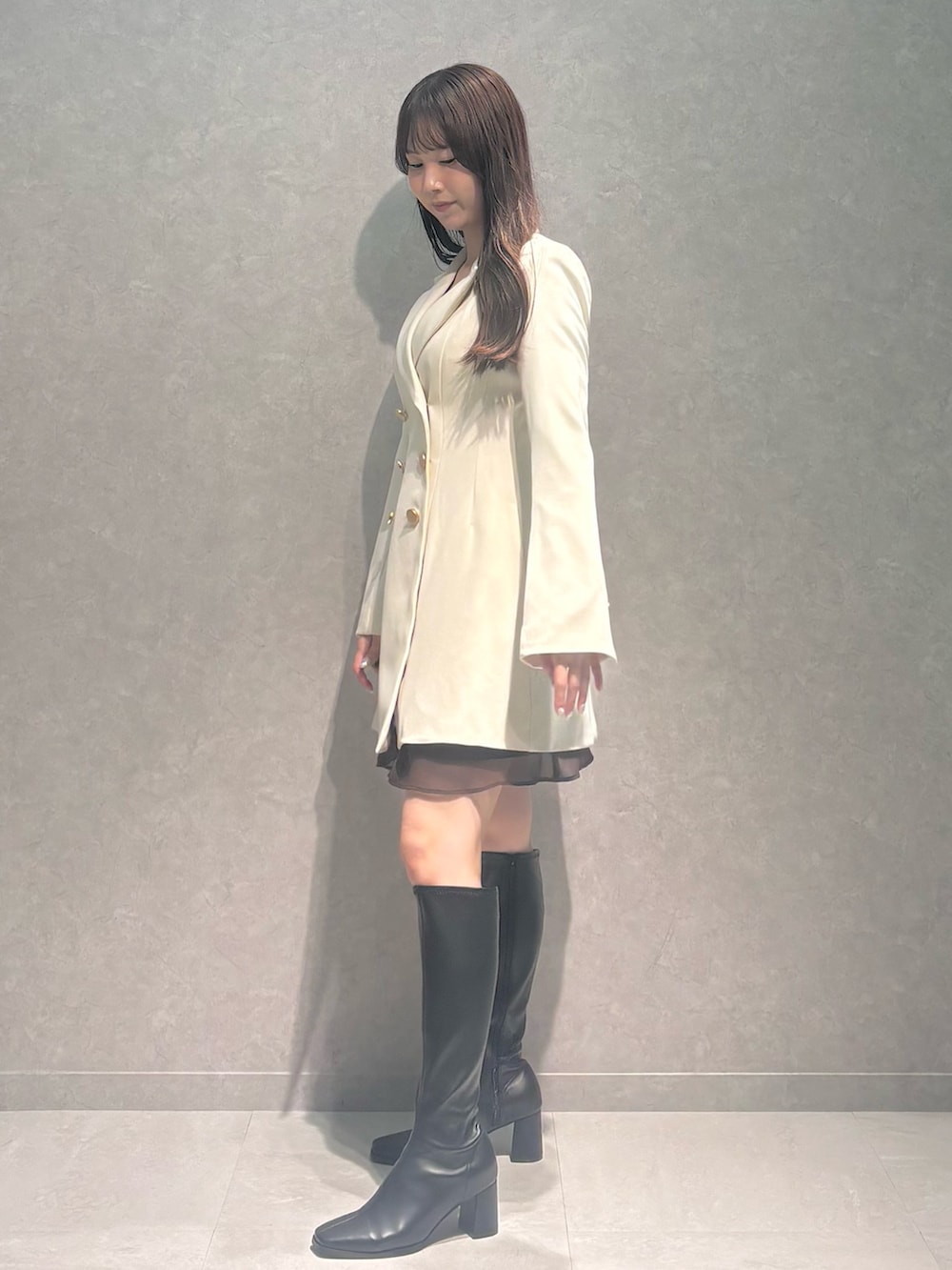 ブラウン系のワンピース、ホワイト系のワンピース、ブラック系のブーツを着用したレディースの秋コーディネートの4枚目の写真