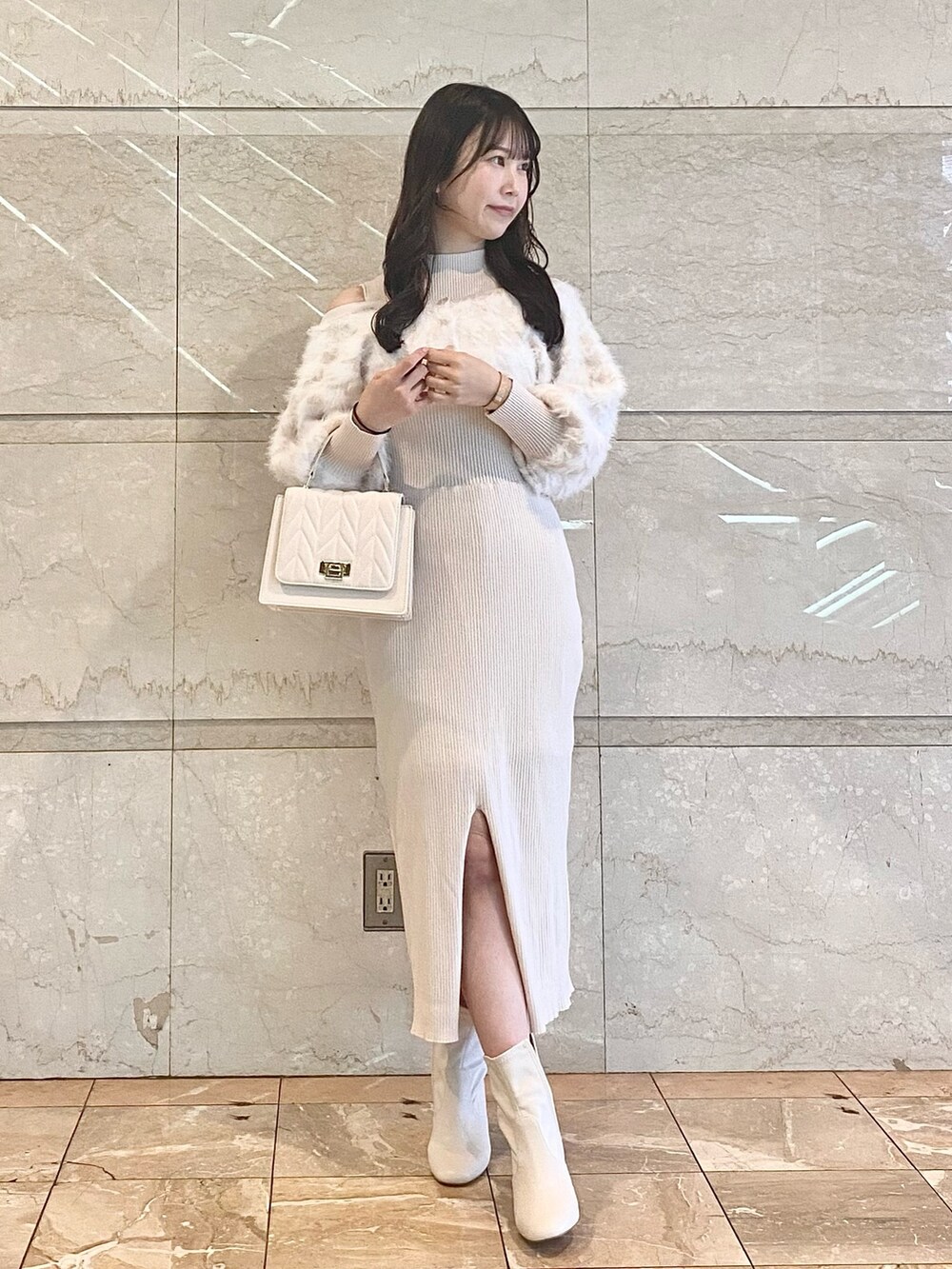 ベージュ系のワンピース、ホワイト系のブーツ、ホワイト系のショルダーバッグを着用したレディースの冬コーディネートの5枚目の写真