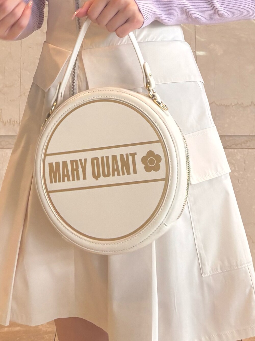 ホワイト系のショルダーバッグ、パープル系のニット/セーター、ホワイト系のスカートを着用したレディースの冬コーディネートの6枚目の写真