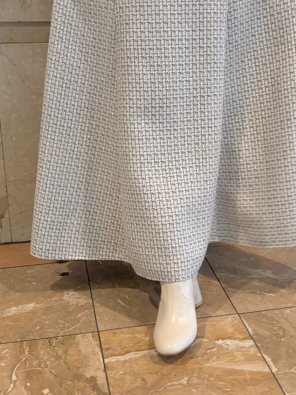 ホワイト系のスカート、ホワイト系のブーツ、ホワイト系のニット/セーターを着用したレディースの冬コーディネートの3枚目の写真