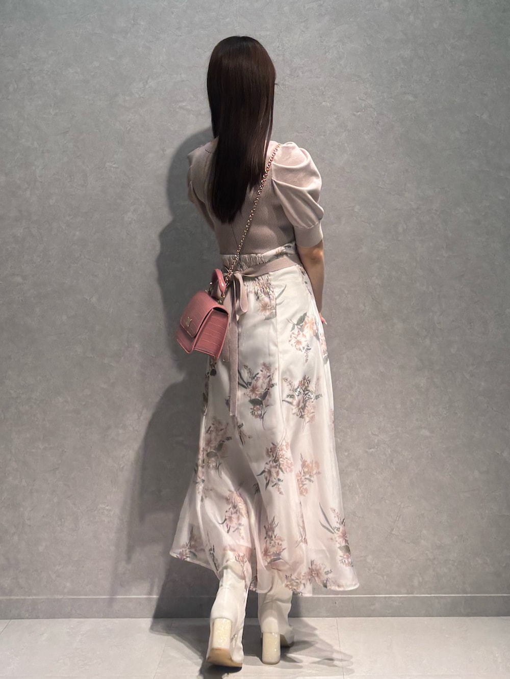 ベージュ系のワンピース、ホワイト系のブーツ、ピンク系のハンドバッグを着用したレディースの冬コーディネートの4枚目の写真