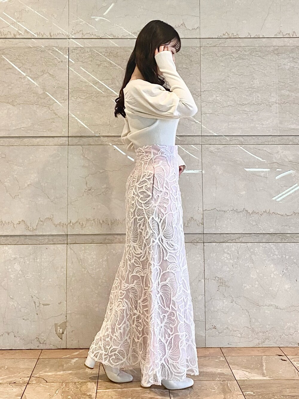 ピンク系のスカート、ホワイト系のブーツ、ホワイト系のニット/セーターを着用したレディースの冬コーディネートの4枚目の写真