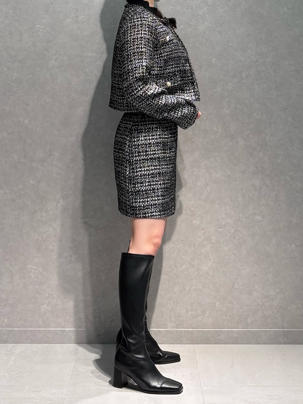 ブラック系のスカート、ブラック系のニット/セーター、ブラック系のテーラードジャケットを着用したレディースの春コーディネートの4枚目の写真