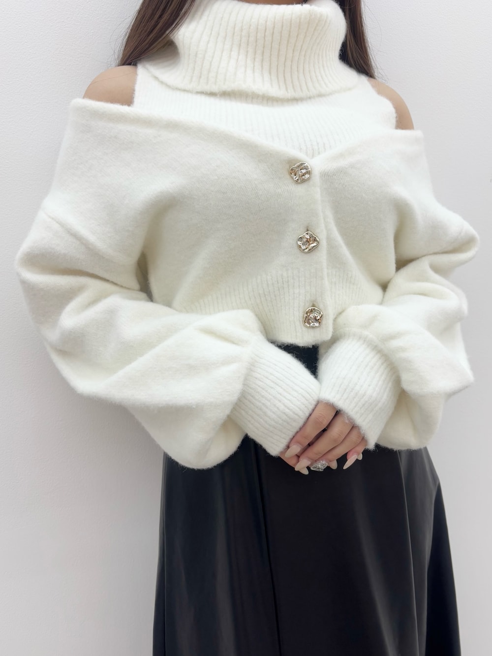 ホワイト系のニット/セーター、ブラック系のスカート、ブラック系のブーツを着用したレディースの冬コーディネートの5枚目の写真