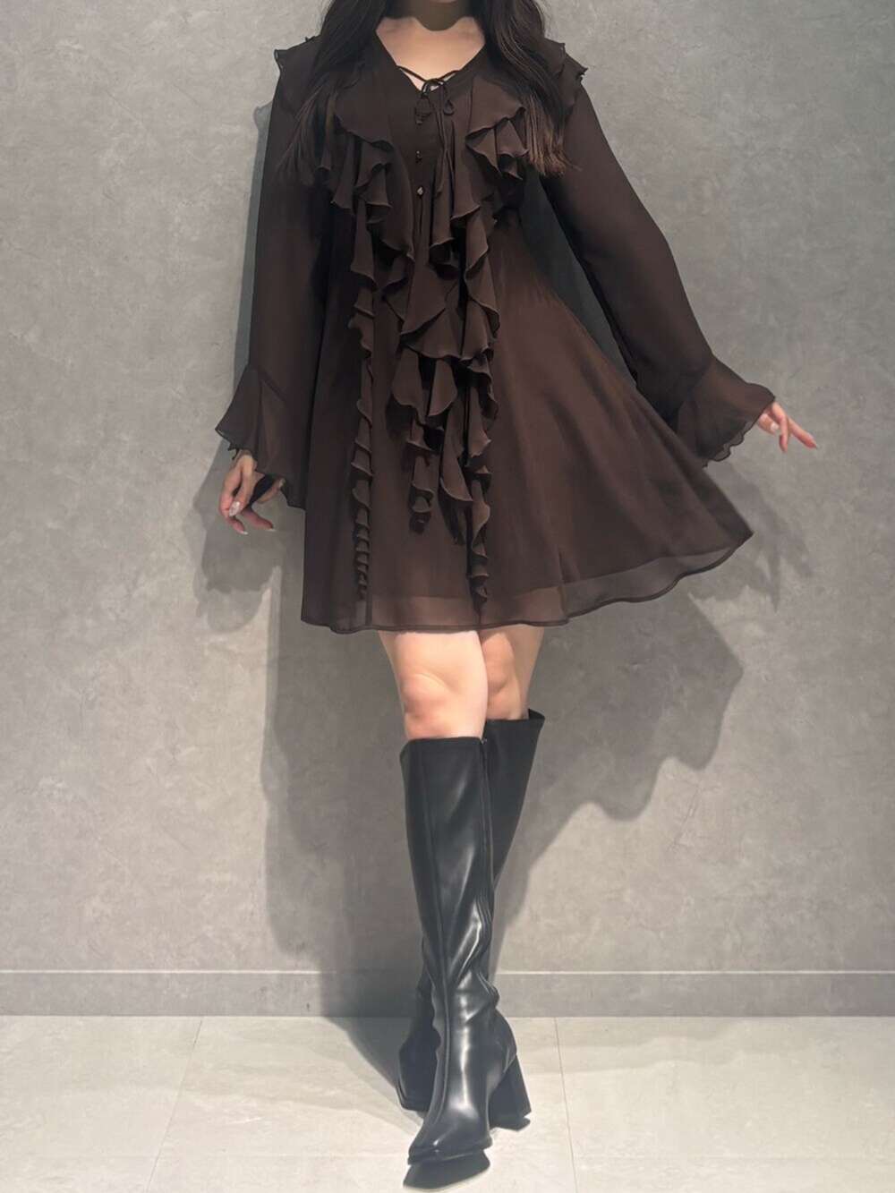 ブラック系のブーツ、ブラウン系のワンピースを着用したレディースの秋コーディネートの4枚目の写真