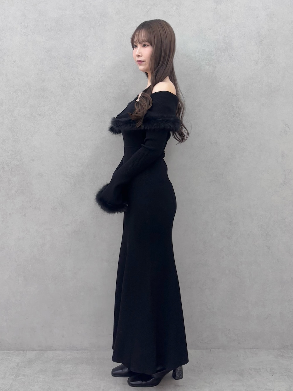 ブラック系のワンピース、ブラック系のブーツを着用したレディースの冬コーディネートの2枚目の写真