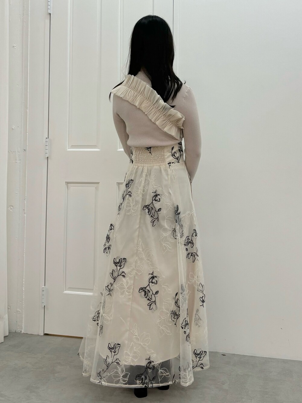 ホワイト系のスカート、ブラウン系のブーツ、ホワイト系のニット/セーターを着用したレディースの秋コーディネートの4枚目の写真