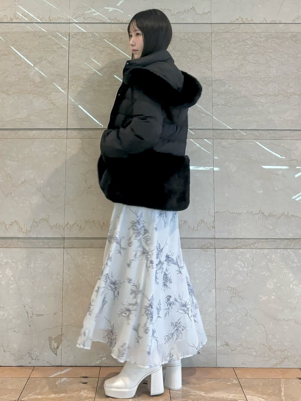 ブラック系のワンピース、ホワイト系のブーツ、ブラック系のその他アウターを着用したレディースの秋コーディネートの3枚目の写真