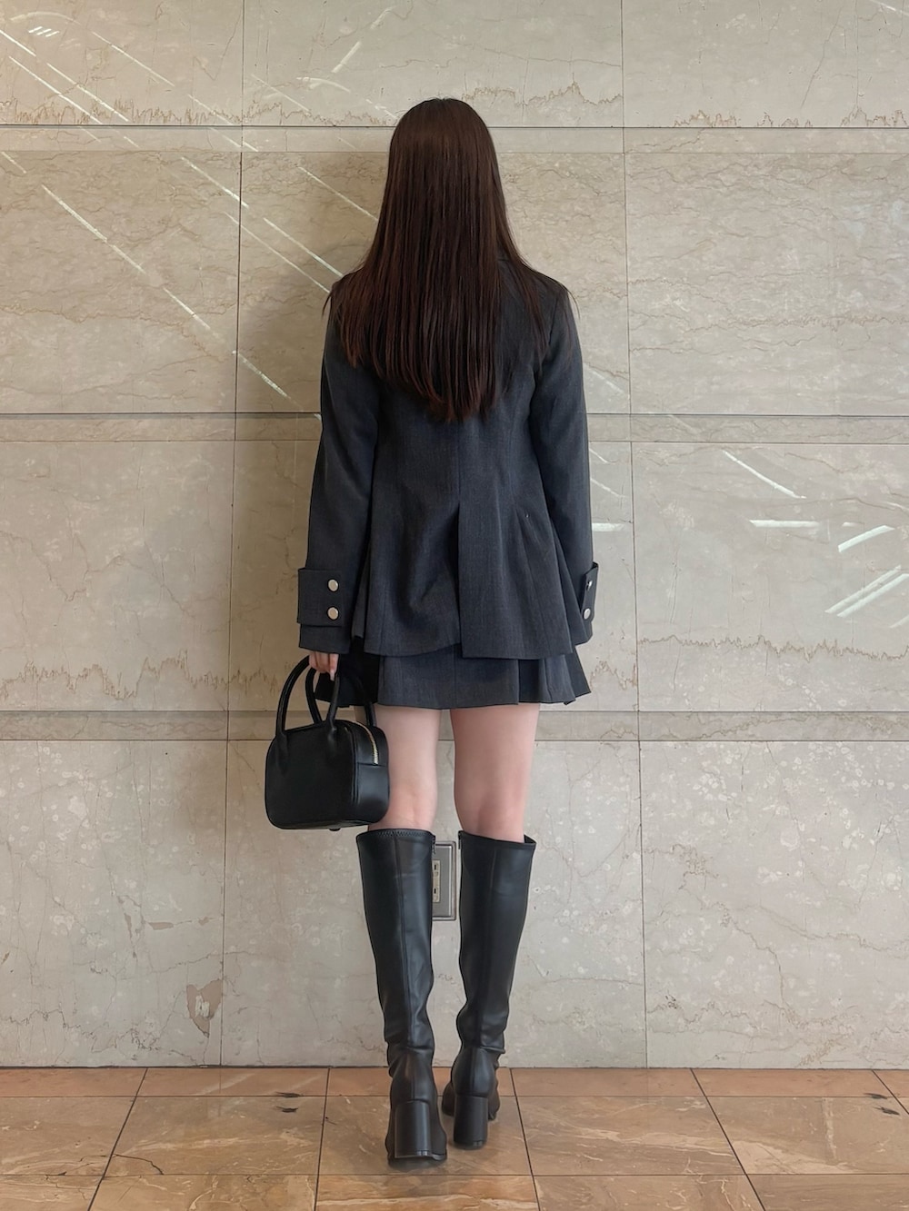 グレー系のスカート、ホワイト系のシャツ/ブラウス、ブラック系のハンドバッグを着用したレディースの秋コーディネートの5枚目の写真