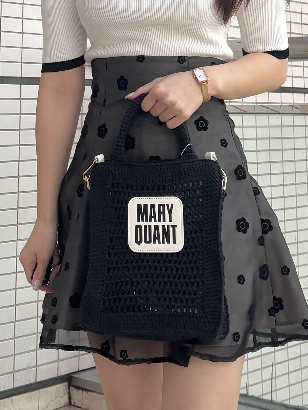 ブラック系のスカート、ブラック系のブーツ、ホワイト系のニット/セーターを着用したレディースの春コーディネートの5枚目の写真