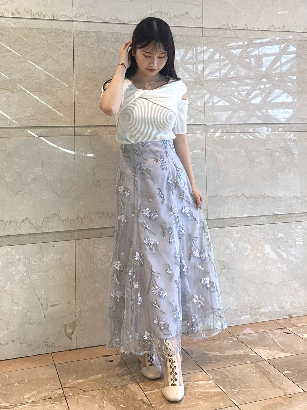 ホワイト系のニット/セーター、ブルー系のスカート、ホワイト系のブーツを着用したレディースの夏コーディネートの2枚目の写真