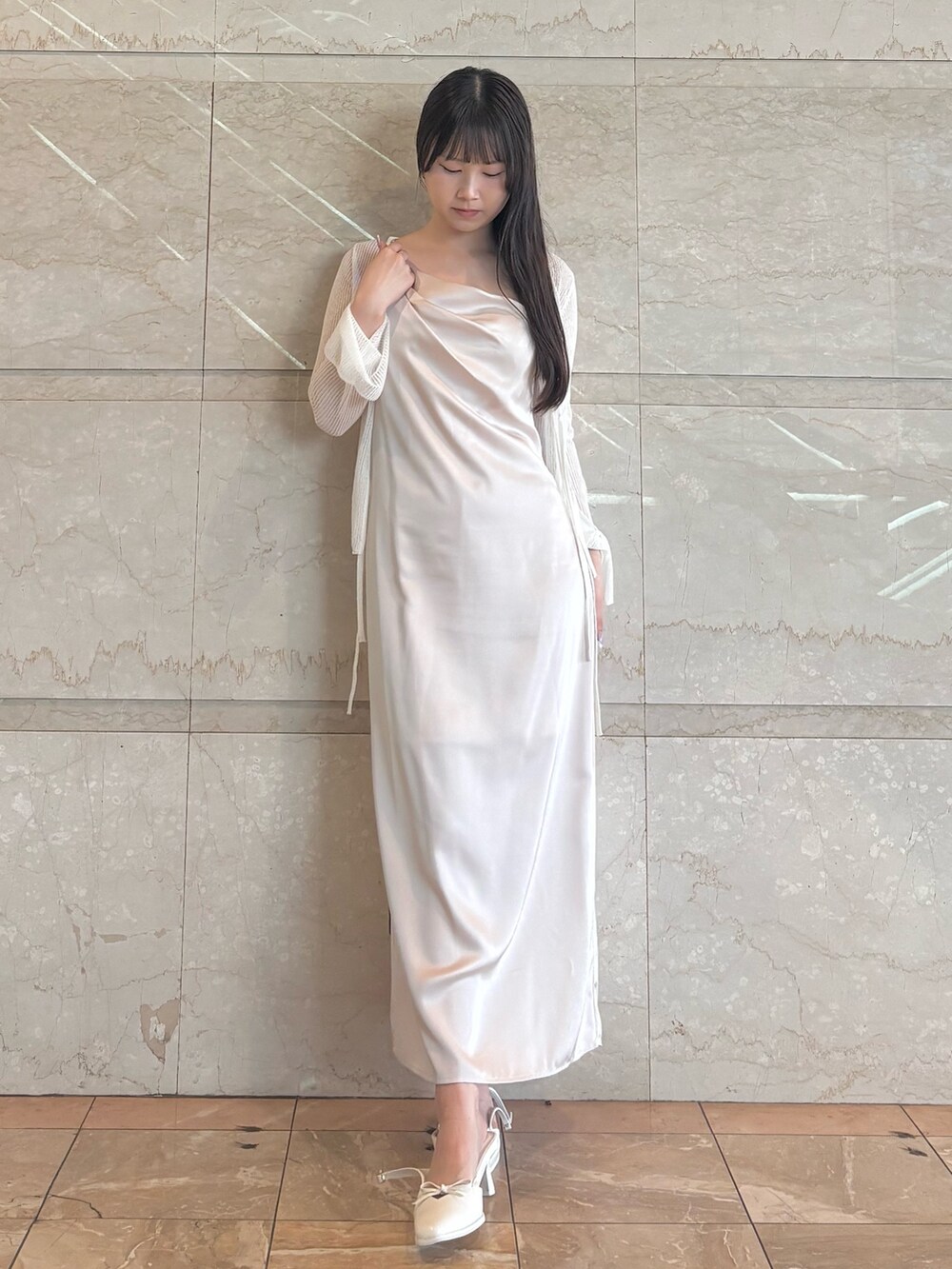 ピンク系のワンピース、ホワイト系のパンプス、ホワイト系のカーディガン/ボレロを着用したレディースの夏コーディネートの2枚目の写真