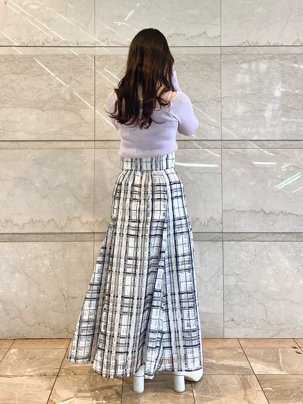 パープル系のニット/セーター、ホワイト系のスカート、ホワイト系のブーツを着用したレディースの冬コーディネートの4枚目の写真