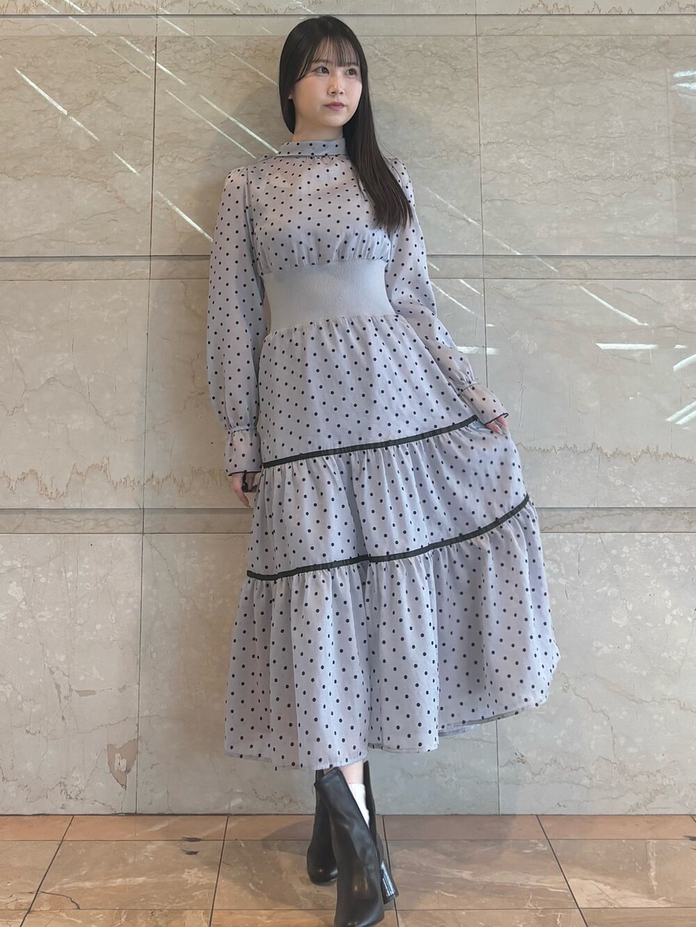 グレー系のワンピース、ブラック系のブーツを着用したレディースの冬コーディネートの3枚目の写真