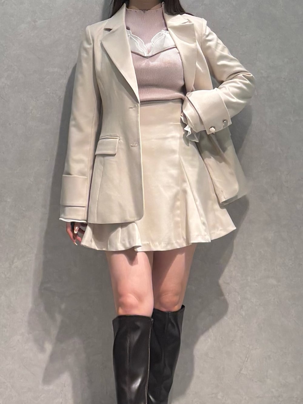 ホワイト系のスカート、ホワイト系のテーラードジャケット、ベージュ系のニット/セーターを着用したレディースの冬コーディネートの2枚目の写真