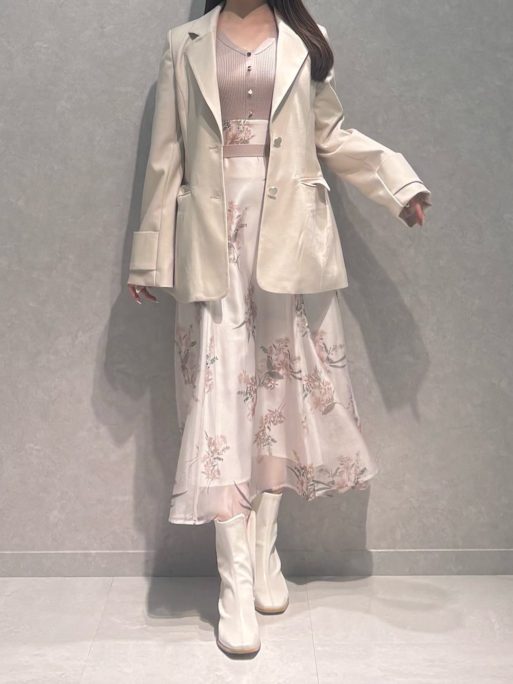 ベージュ系のワンピース、ホワイト系のテーラードジャケット、ホワイト系のブーツを着用したレディースの春コーディネートの3枚目の写真