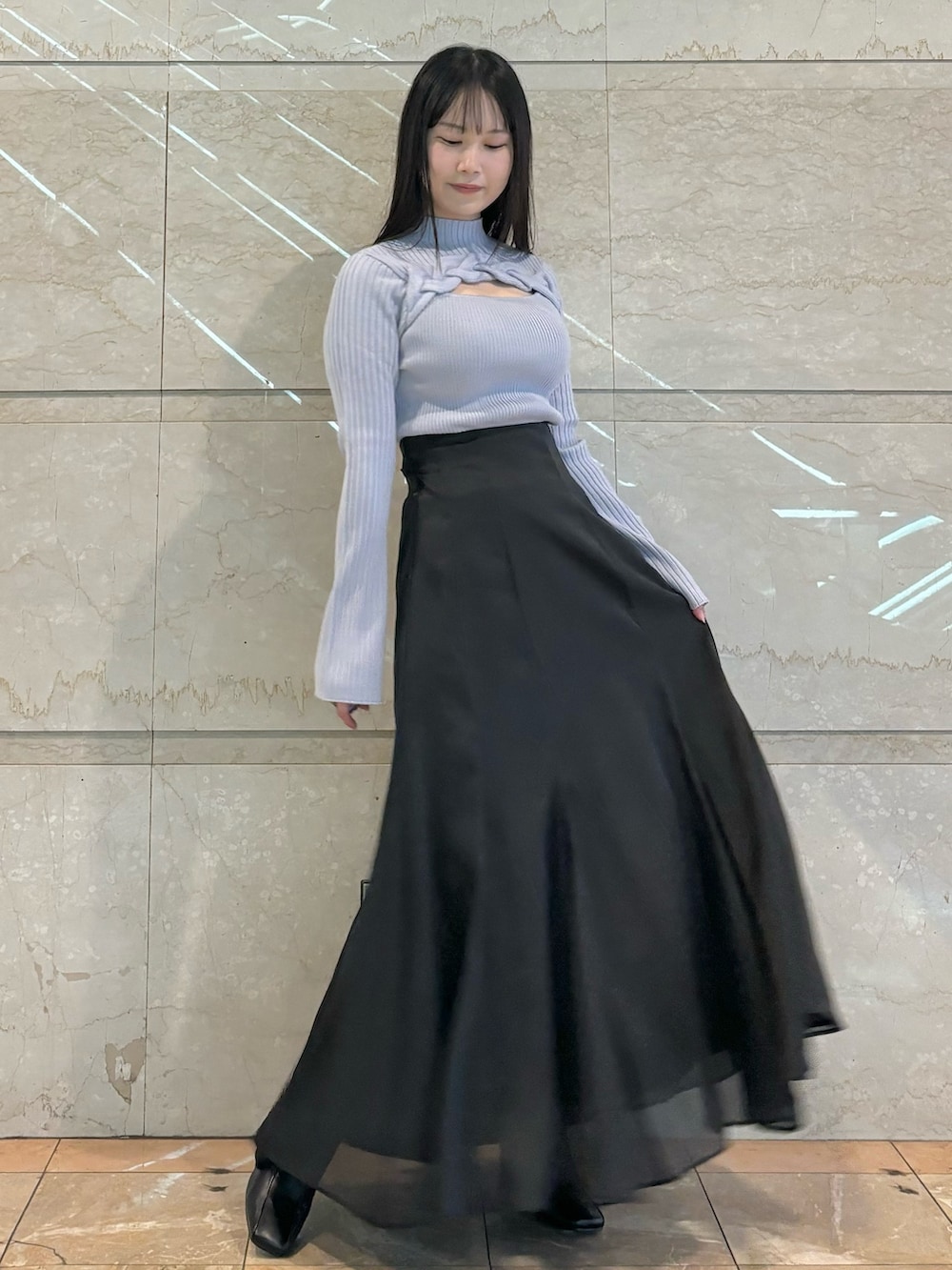 ブラック系のスカート、ブラック系のブーツ、ブルー系のニット/セーターを着用したレディースの秋コーディネートの2枚目の写真