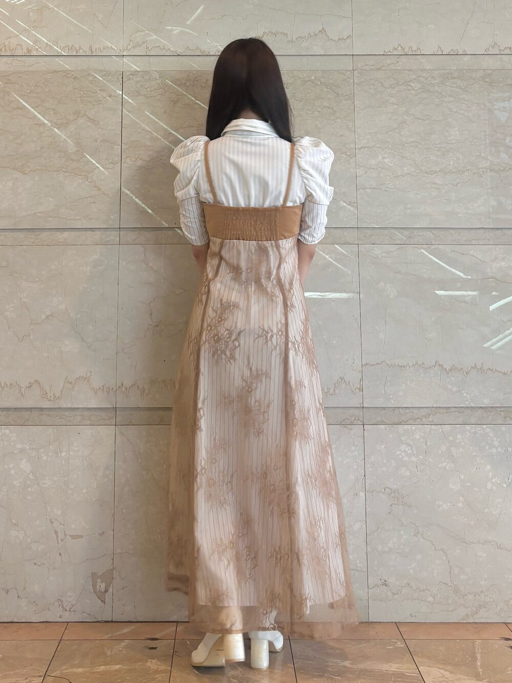 ベージュ系のワンピース、ホワイト系のブーツを着用したレディースの秋コーディネートの4枚目の写真