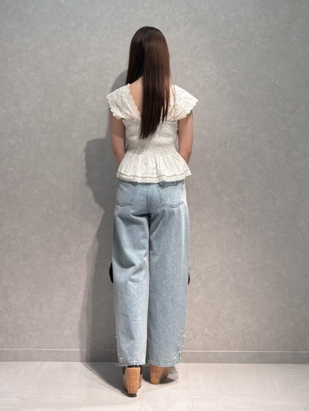 ブルー系のデニムパンツ、ブラウン系のサンダル、ホワイト系のシャツ/ブラウスを着用したレディースの夏コーディネートの5枚目の写真