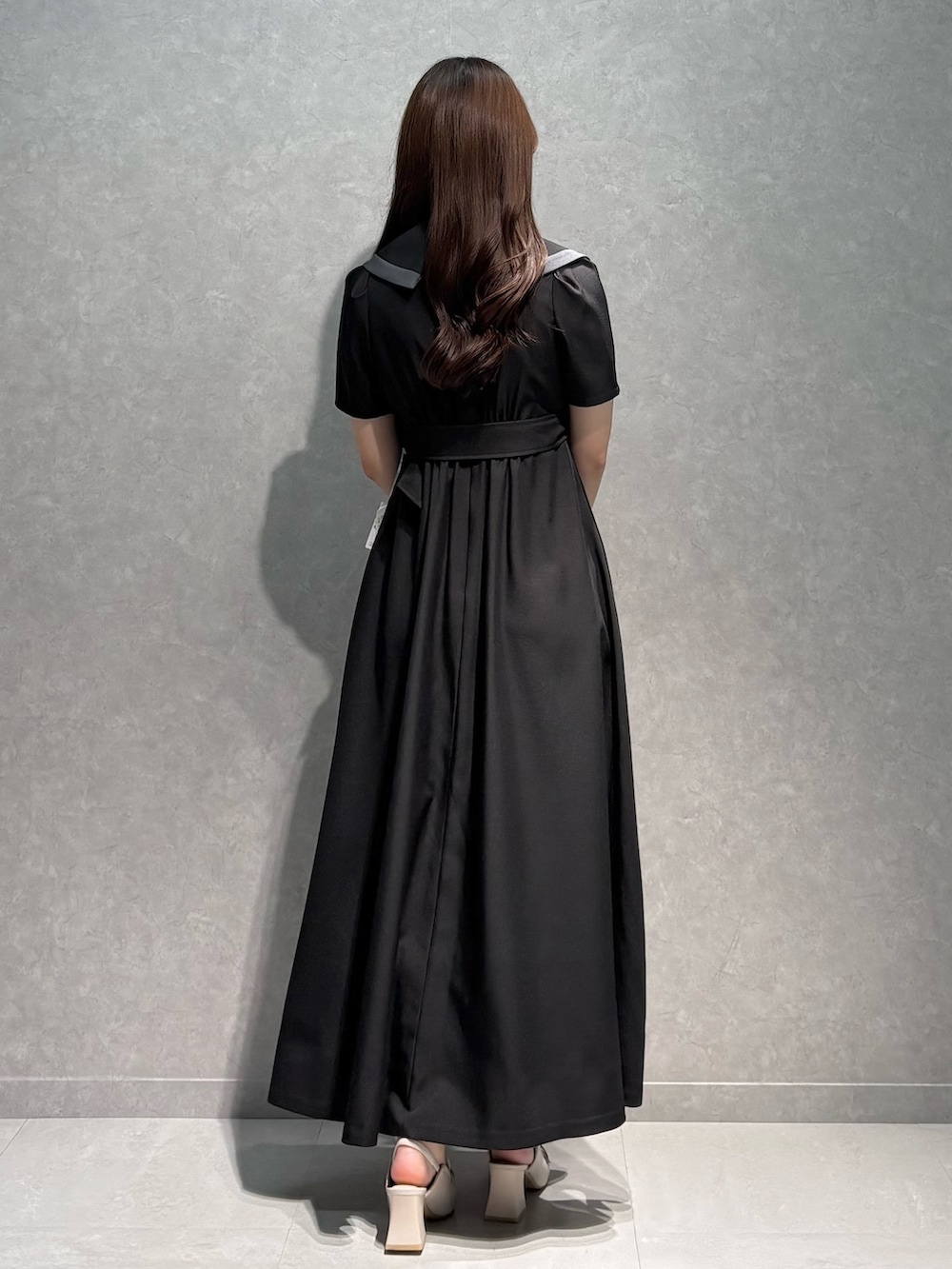 ブラック系のワンピース、ホワイト系のパンプス、ホワイト系のハンドバッグを着用したレディースの春コーディネートの6枚目の写真