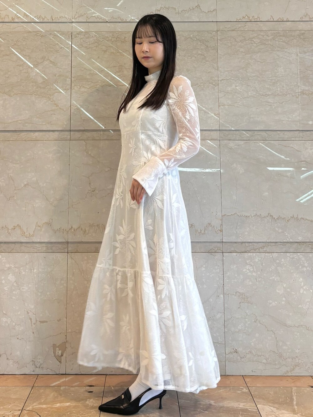 ホワイト系のワンピース、ブラック系のパンプスを着用したレディースの冬コーディネートの2枚目の写真