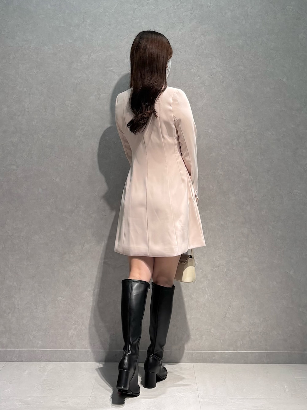 ピンク系のワンピース、ホワイト系のハンドバッグ、ブラック系のブーツを着用したレディースの春コーディネートの6枚目の写真