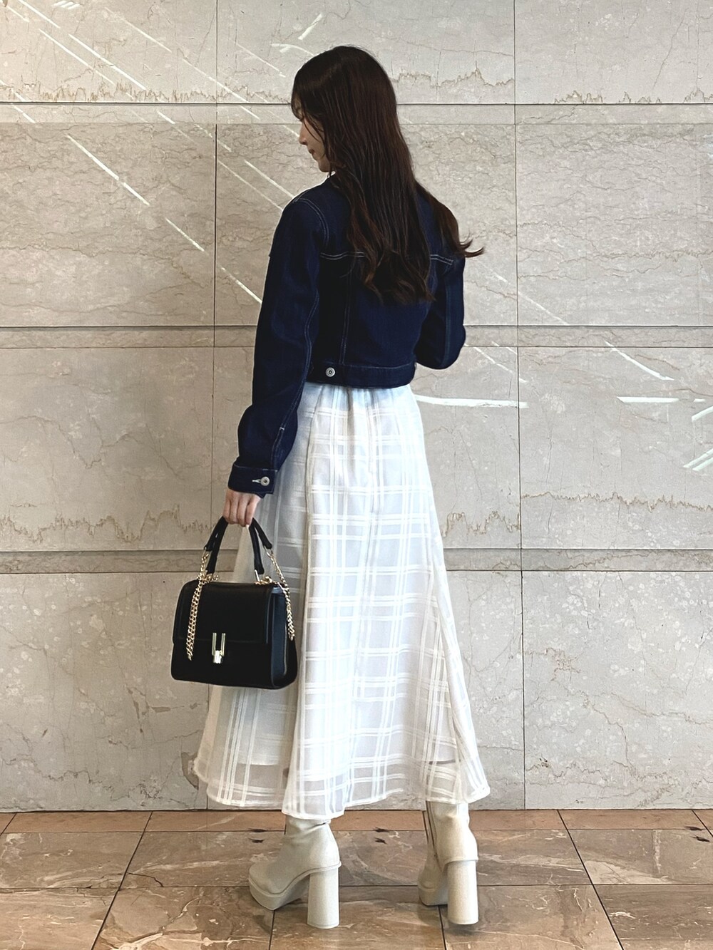 ホワイト系のワンピース、ホワイト系のブーツ、ブラック系のショルダーバッグを着用したレディースの秋コーディネートの3枚目の写真