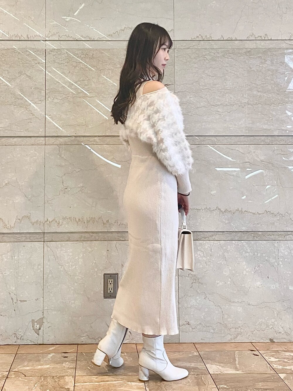 ベージュ系のワンピース、ホワイト系のブーツ、ホワイト系のショルダーバッグを着用したレディースの冬コーディネートの3枚目の写真