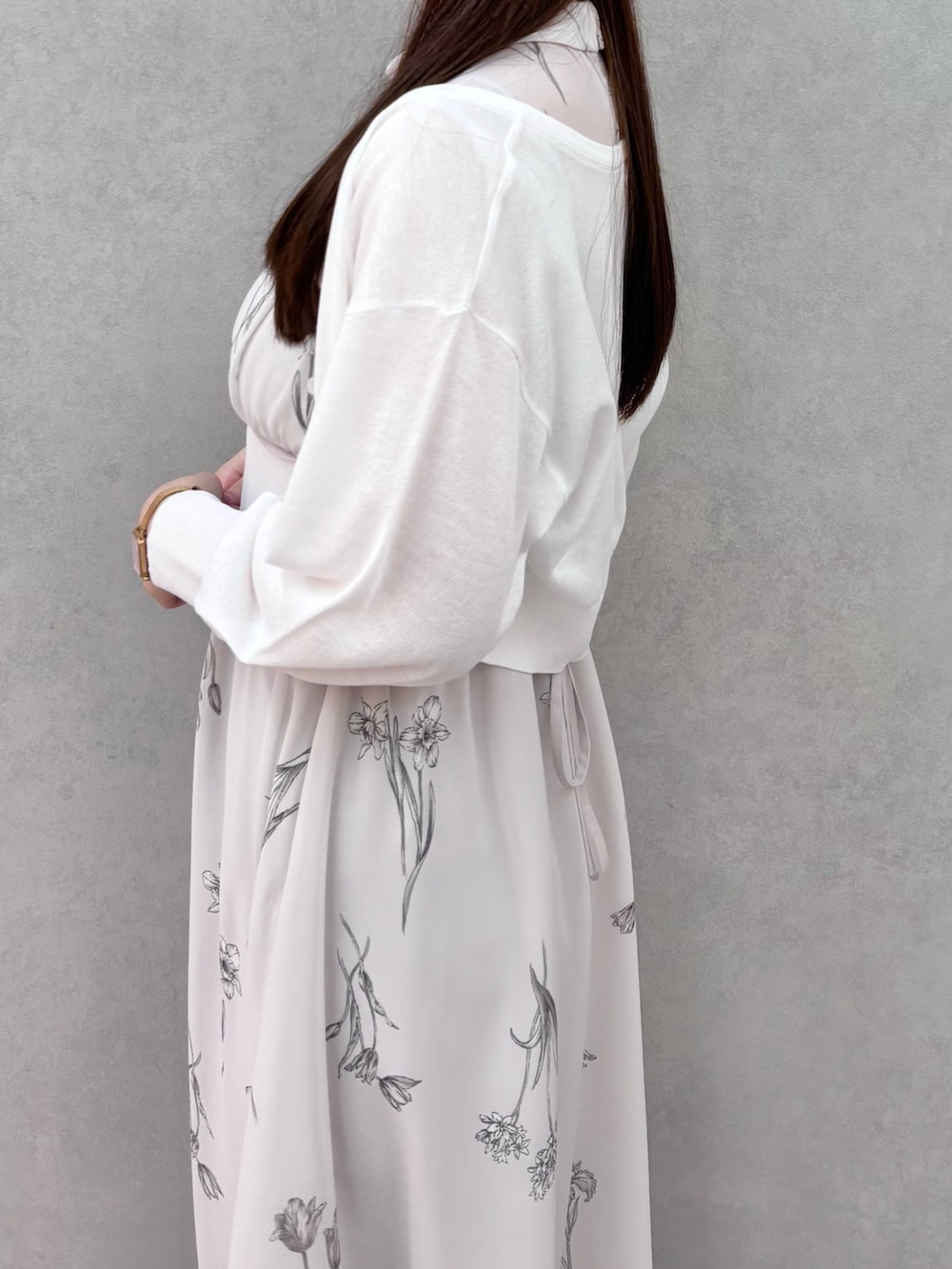 グレー系のワンピース、シルバー系のサンダル、ホワイト系のカーディガン/ボレロを着用したレディースの春コーディネートの5枚目の写真