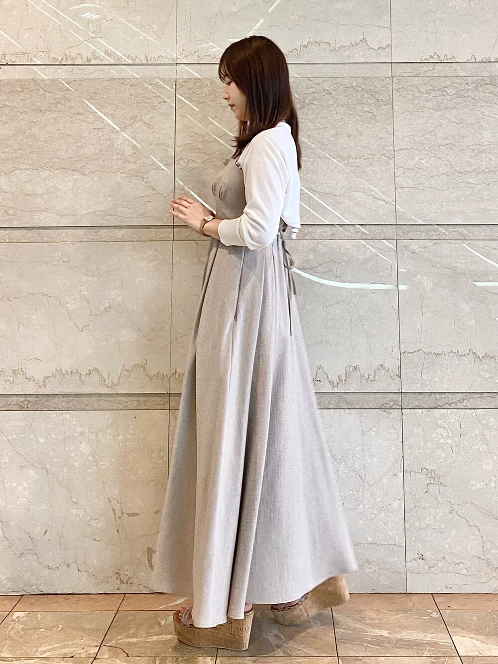 ベージュ系のワンピース、ホワイト系のカーディガン/ボレロ、その他のサンダルを着用したレディースの春コーディネートの6枚目の写真