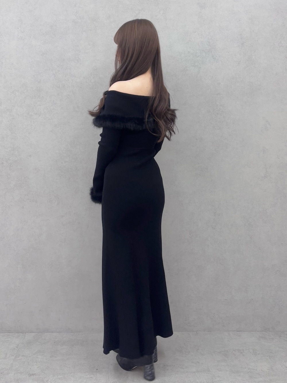 ブラック系のワンピース、ブラック系のブーツを着用したレディースの冬コーディネートの4枚目の写真