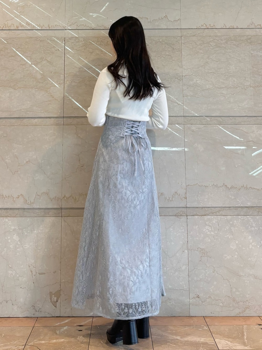 ブルー系のショルダーバッグ、ブラック系のブーツ、ブルー系のスカートを着用したレディースの冬コーディネートの4枚目の写真