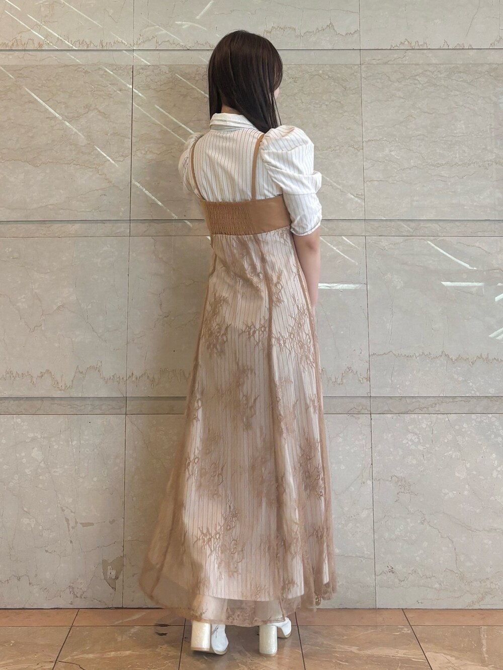 ベージュ系のワンピース、ホワイト系のブーツを着用したレディースの秋コーディネートの5枚目の写真