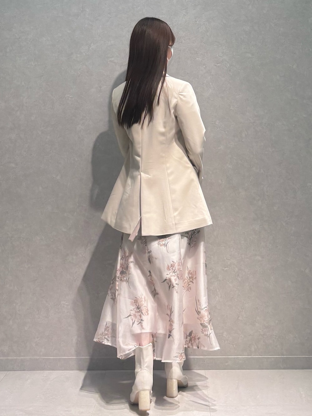 ベージュ系のワンピース、ホワイト系のテーラードジャケット、ホワイト系のブーツを着用したレディースの春コーディネートの6枚目の写真