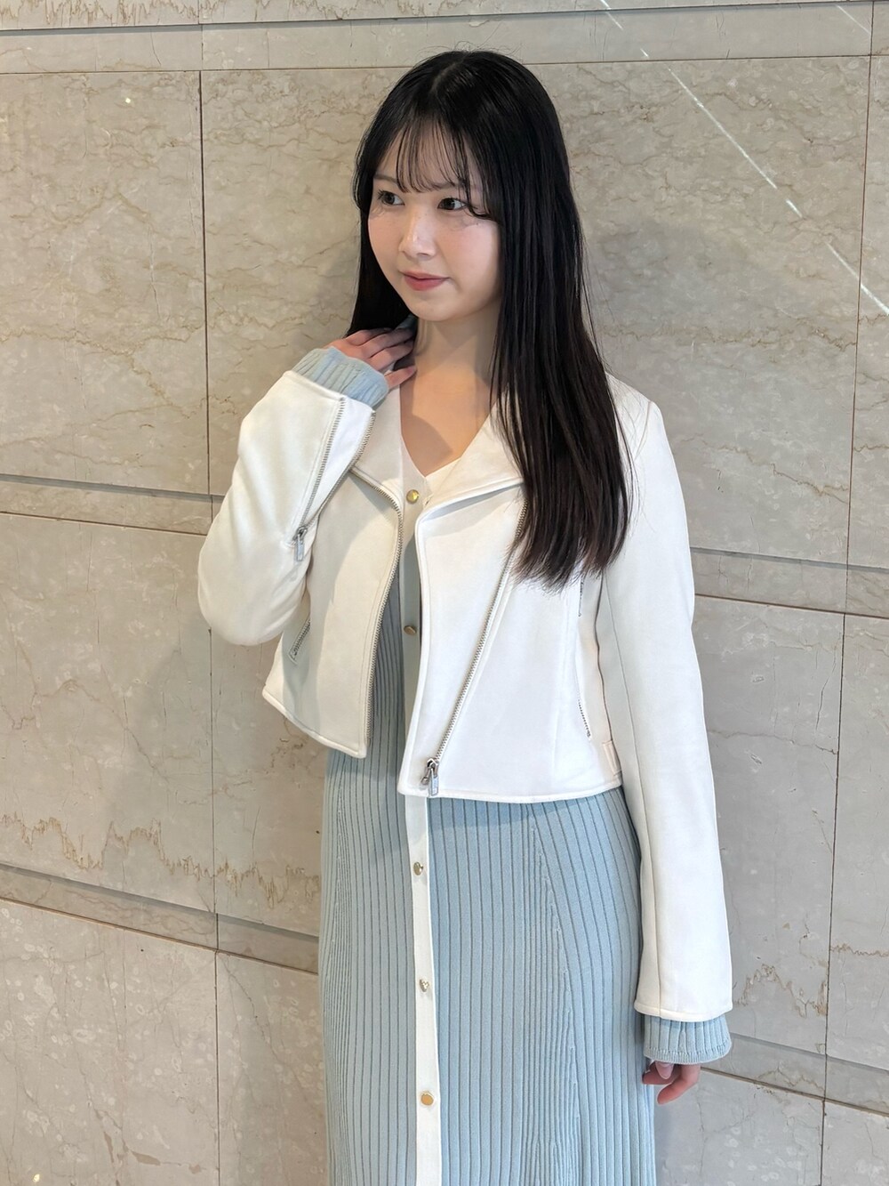 ブルー系のワンピース、ホワイト系のブーツ、ホワイト系のライダースジャケットを着用したレディースの冬コーディネートの5枚目の写真