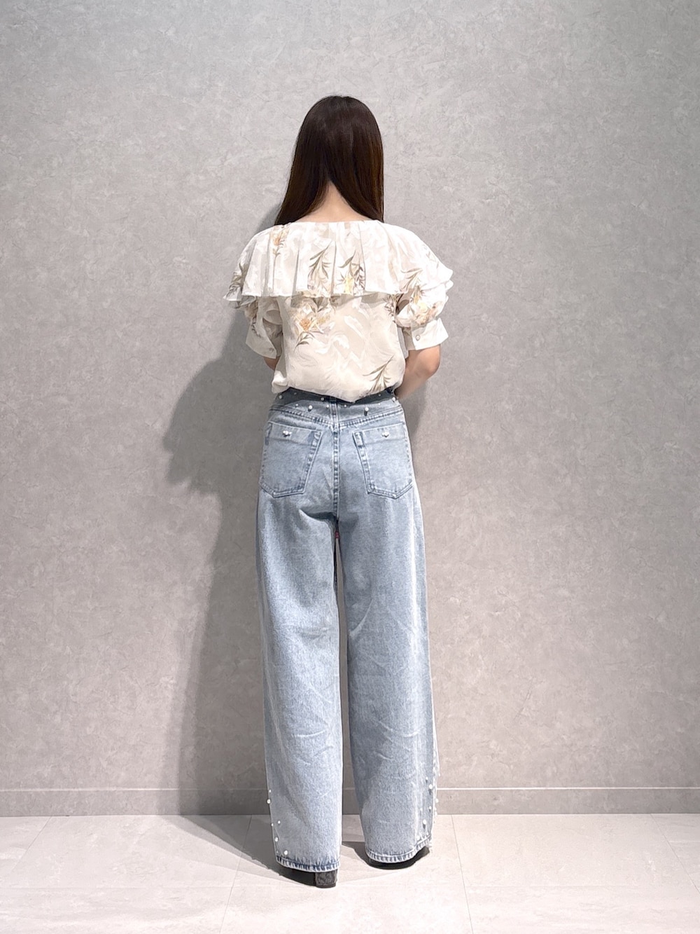 ホワイト系のシャツ/ブラウス、ブラウン系のハンドバッグ、ブルー系のデニムパンツを着用したレディースの秋コーディネートの5枚目の写真