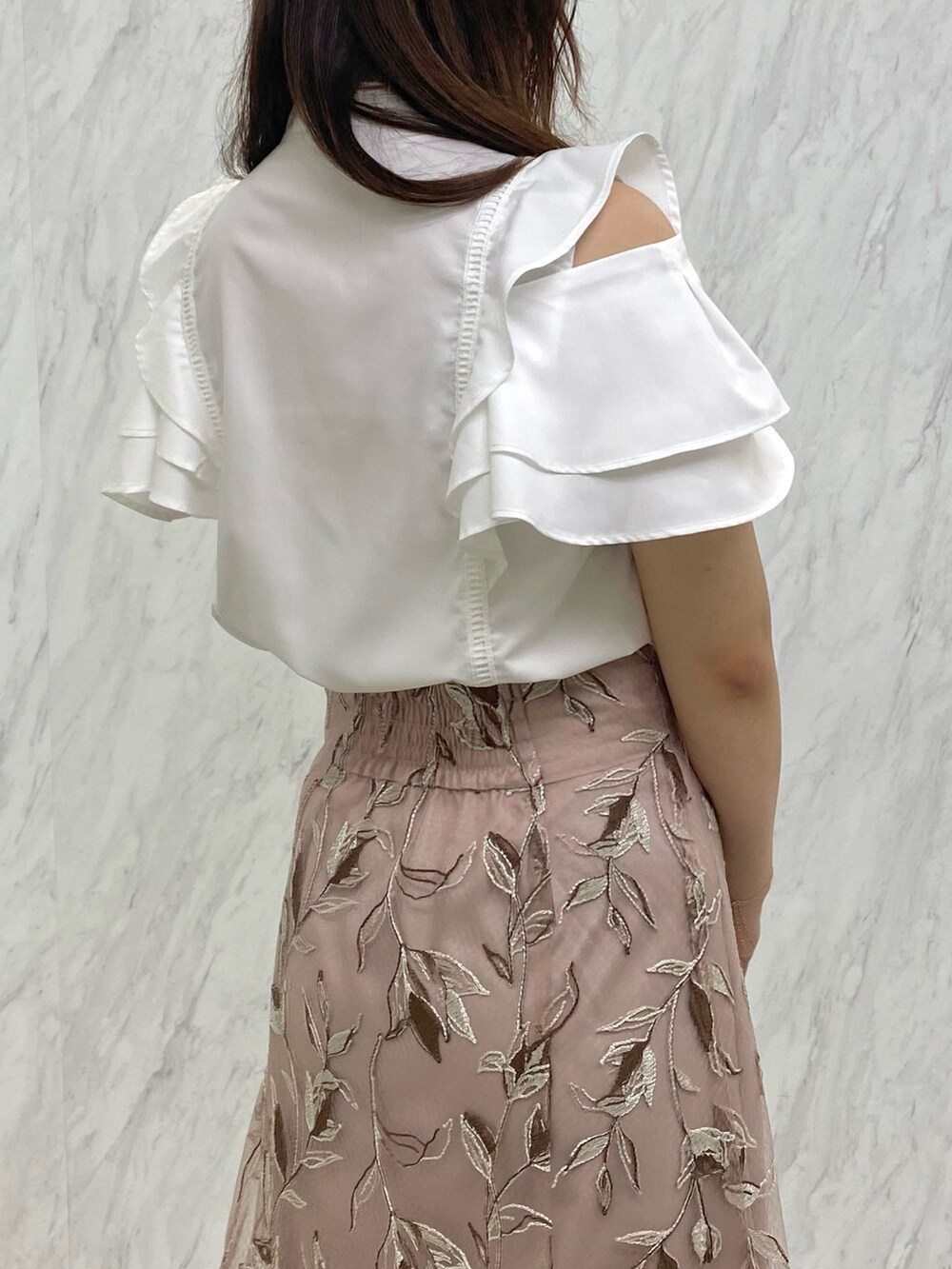 ピンク系のスカート、ホワイト系のシャツ/ブラウス、ホワイト系のパンプスを着用したレディースの夏コーディネートの4枚目の写真