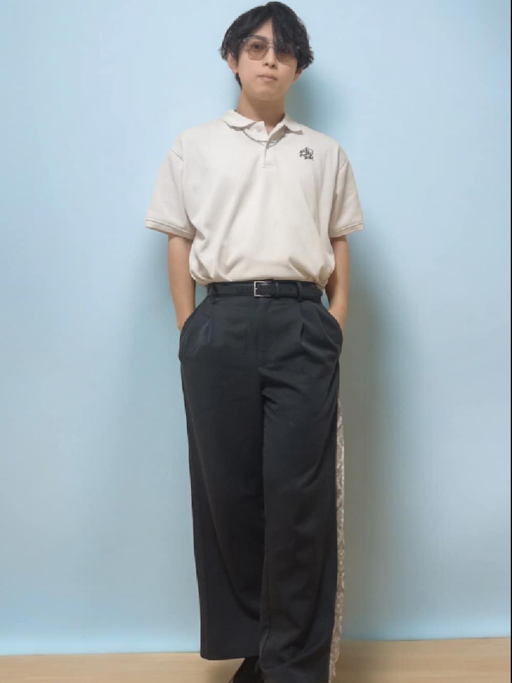 ホワイト系のポロシャツ、ブラック系のスラックス、ブラック系のローファーを着用したメンズの春コーディネートの2枚目の写真