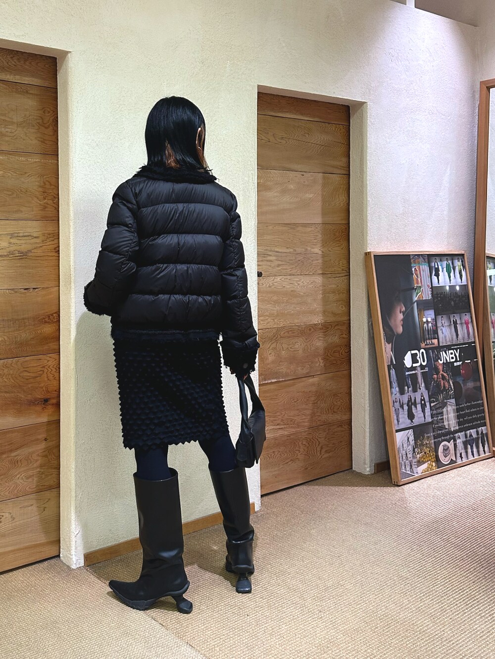 ブラック系のダウンジャケット/コート、ブラック系のスカート、ブラック系のバッグを着用したレディースの冬コーディネートの2枚目の写真