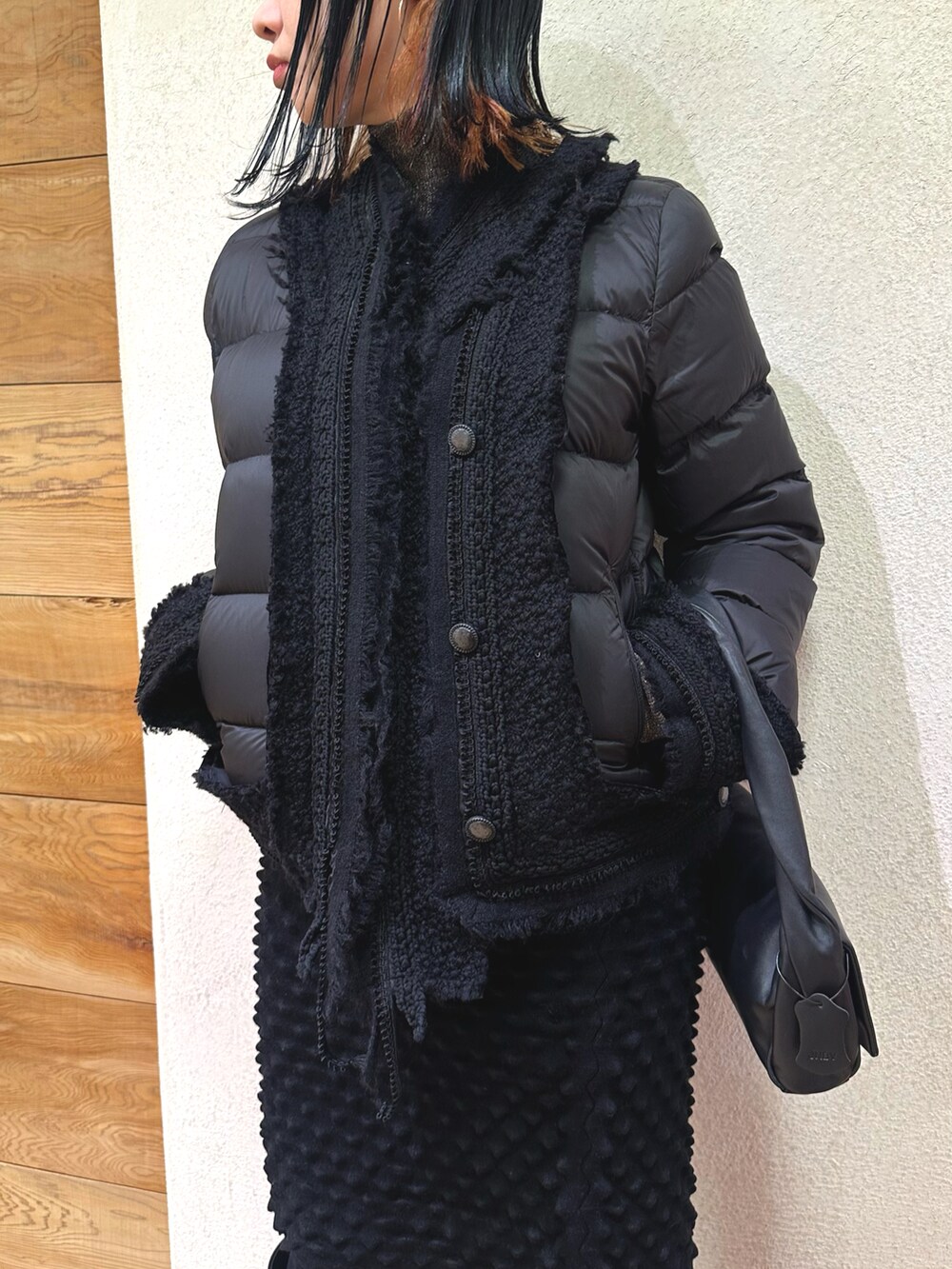 ブラック系のダウンジャケット/コート、ブラック系のスカート、ブラック系のバッグを着用したレディースの冬コーディネートの4枚目の写真